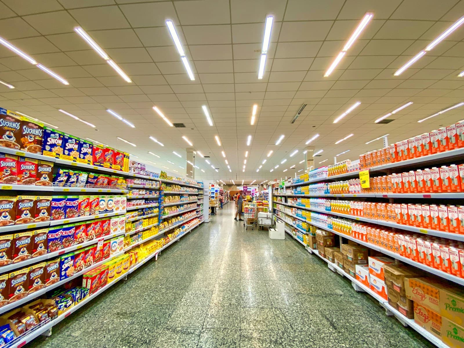 Shelves of packaged goods along a shop aisle